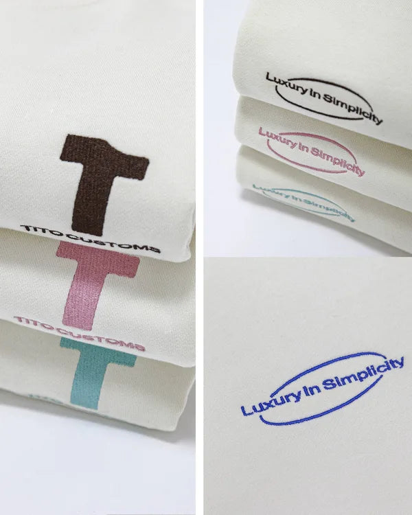 Detalles de cerca: logos TITO CUSTOMS y Luxury in Simplicity en sudaderas dobladas