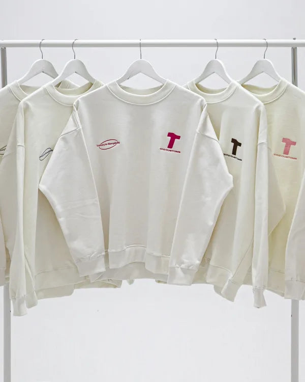 Sudaderas color crudo TITO CUSTOMS colgadas de frente en un burro