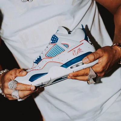 Jordan 4 blancas y azules con la firma de El Alfa